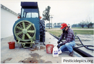 man mixing pesticides over a concrete pad